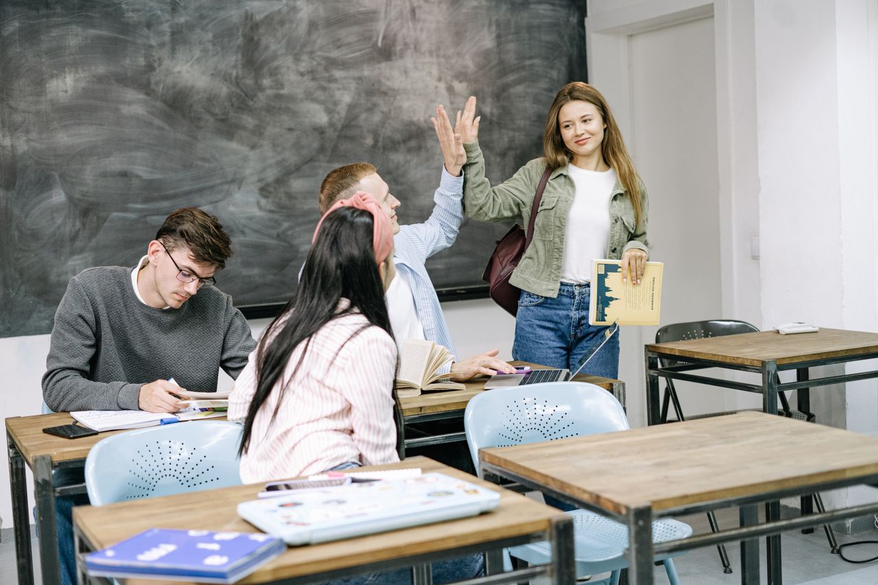 Home Group of students interacting and studying in a college classroom setting.